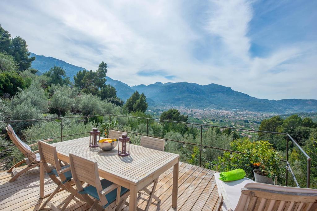 a wooden table and chairs on a deck with a view at Els Abats in Sóller