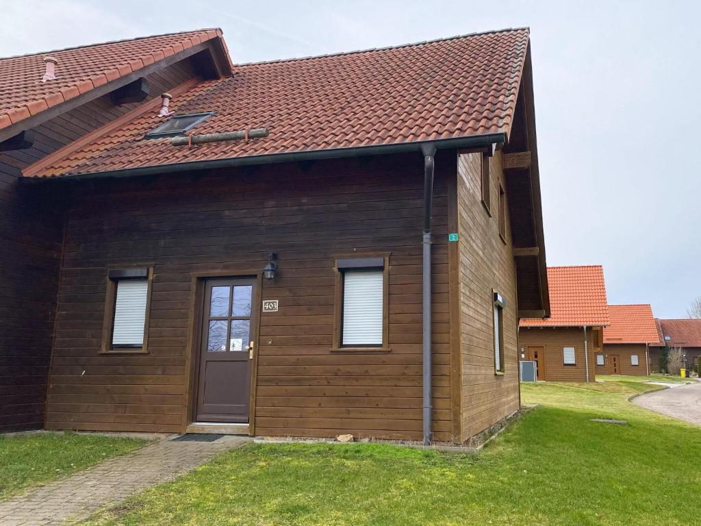 une petite maison en bois avec un toit marron dans l'établissement Semi-detached house, Hasselfelde, à Hasselfelde