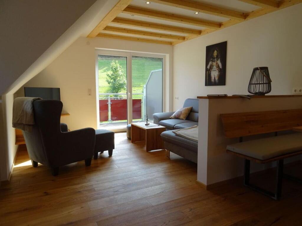 een woonkamer met een bank en een stoel bij Holiday apartment Kieschtock in Unterkirnach