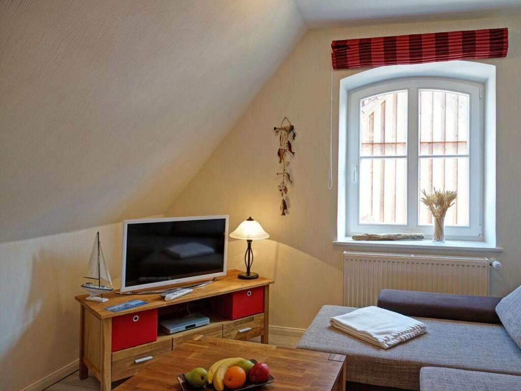 un salon avec une télévision et une table dans l'établissement Apartment in Lancken-Granitz, à Lancken-Granitz