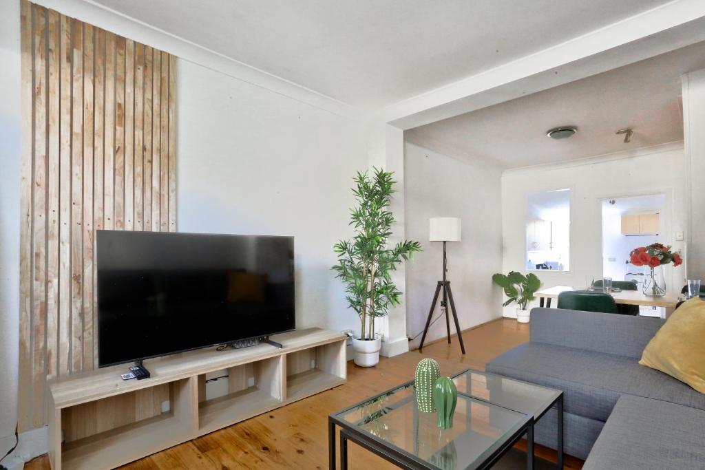 a living room with a large flat screen tv at Delightful 2 Bedroom House Pyrmont 2 E-Bikes Included in Sydney