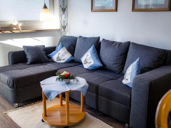 - un salon avec un canapé bleu et une table dans l'établissement Cosy apartment in Bolsterlang, à Bolsterlang