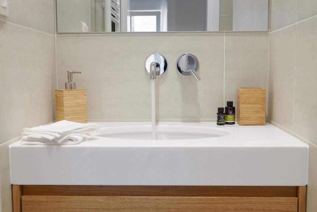 a bathroom counter with a sink and a mirror at Top Center kolonaki Apartment in Athens