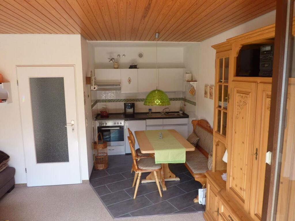 una pequeña cocina con mesa y sofá en Holiday apartment Biermann, en Schluchsee