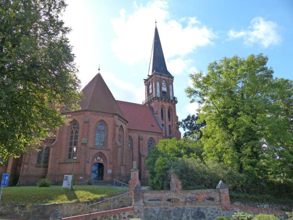 una gran iglesia de ladrillo con un campanario en la parte superior en Apartment in Ostseebad Ahrenshoop, en Wustrow