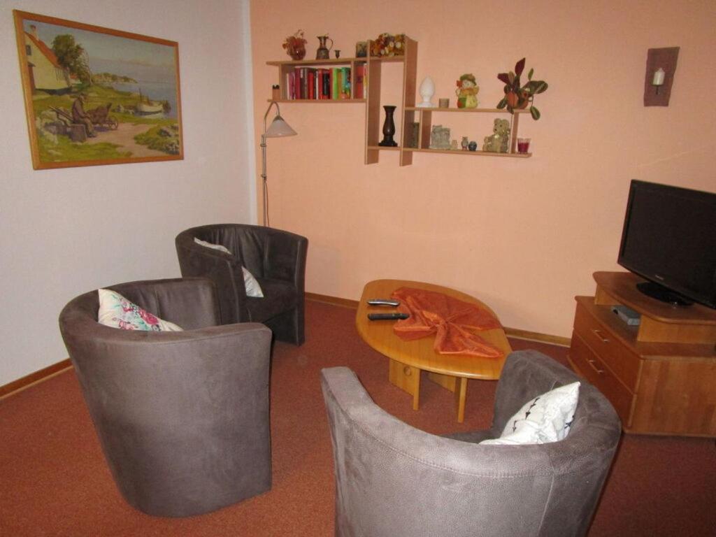 - un salon avec 2 chaises, une table et une télévision dans l'établissement Holiday apartment Anita Wald, à Bad Münstereifel