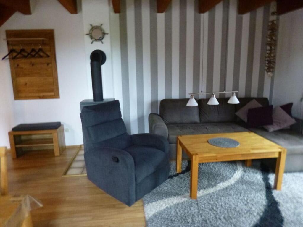 een woonkamer met een bank en een houtkachel bij Holiday home Christmann in Hooksiel