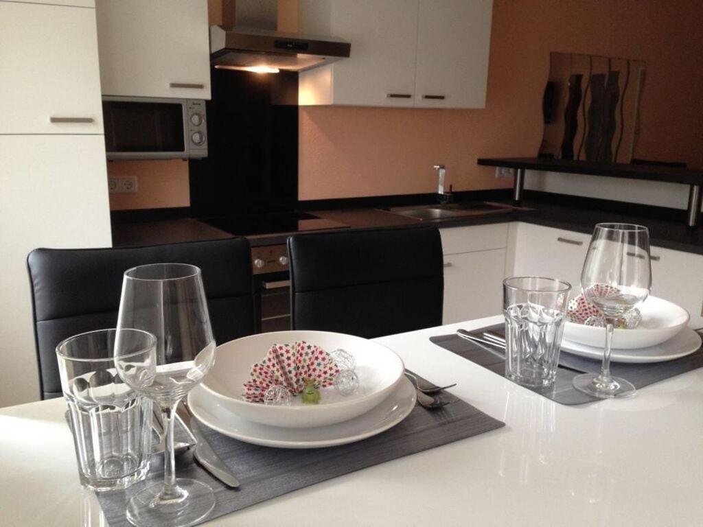 uma mesa com dois pratos e copos numa cozinha em Lively apartment in Mönchsroth 