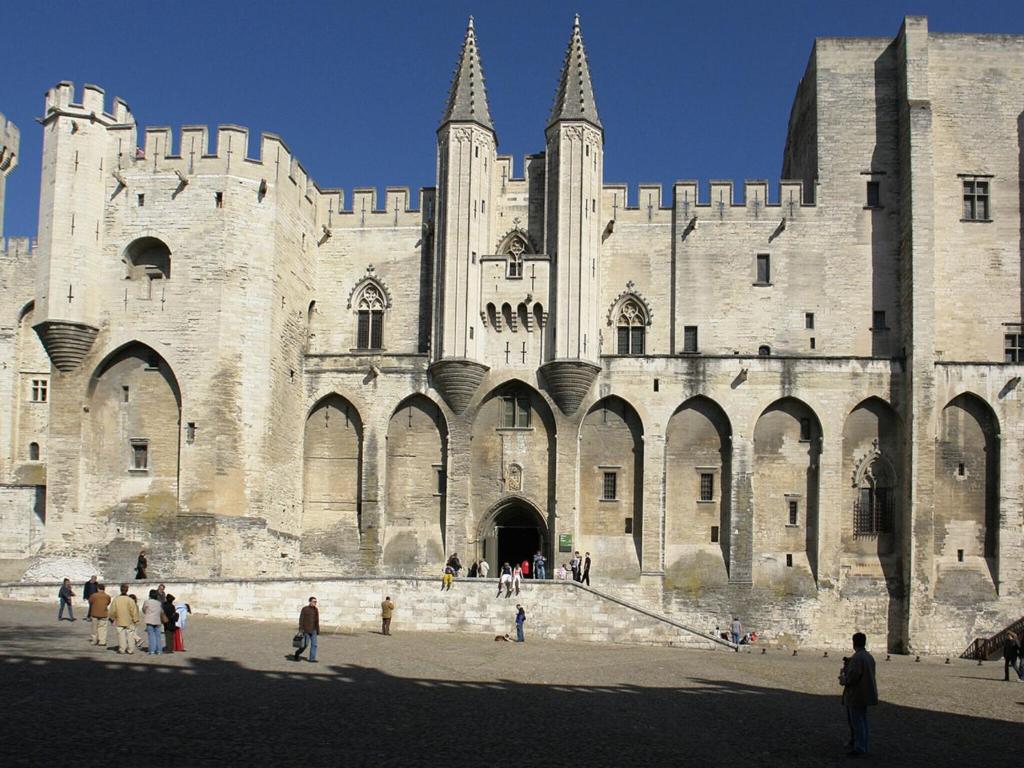 a large castle with people standing outside of it at Magnificent Villa in Saint Ambroix with Private Pool in Saint-Ambroix