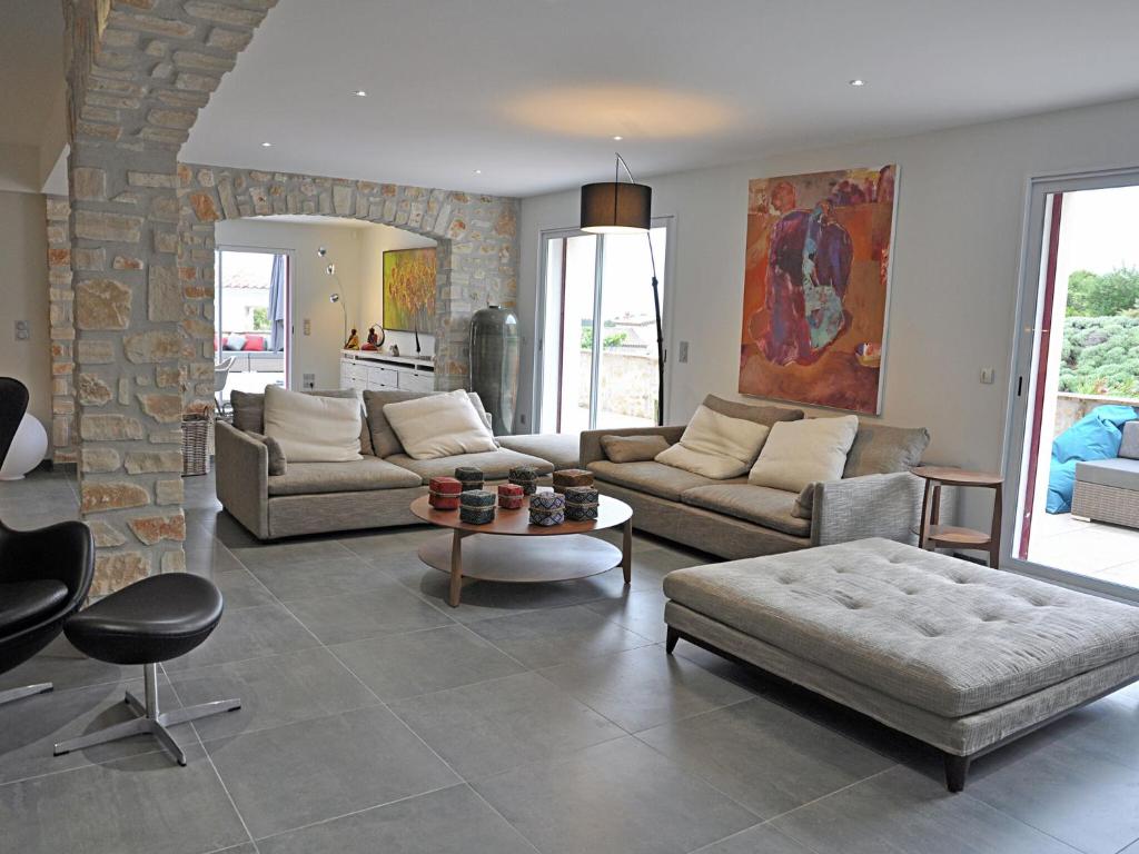 a living room with couches and a stone wall at Magnificent Villa in Saint Ambroix with Private Pool in Saint-Ambroix