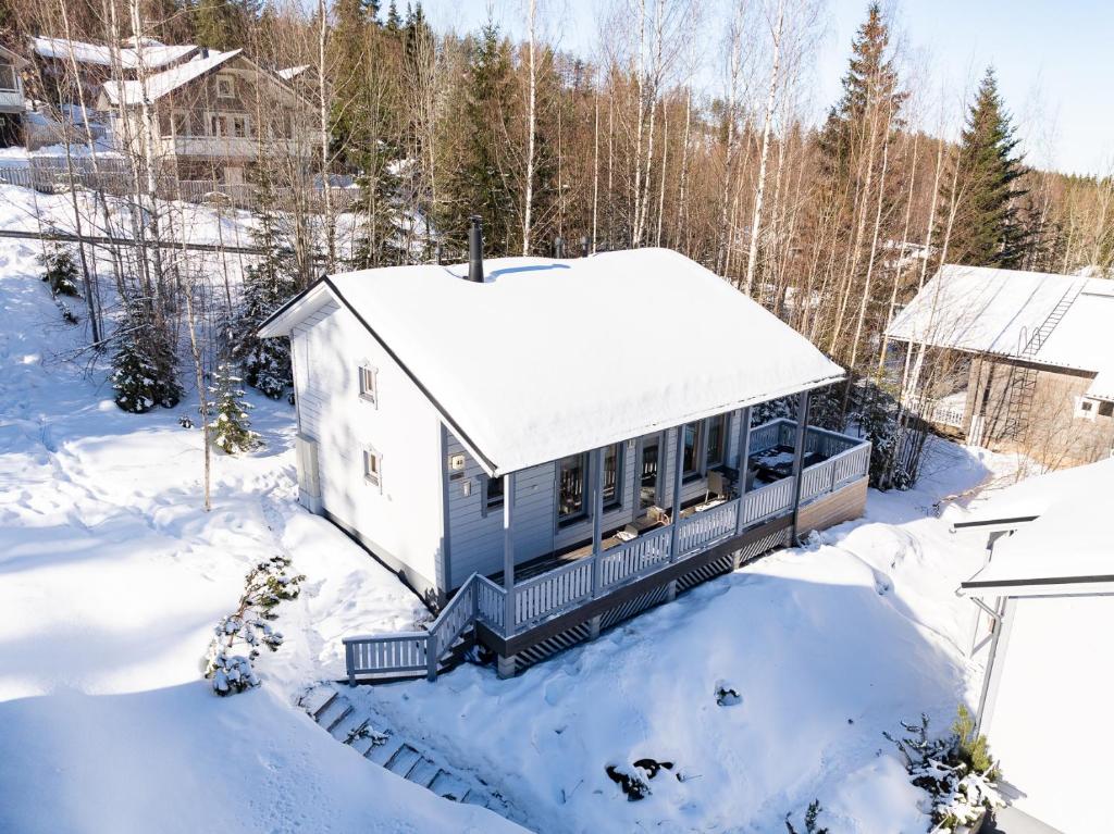 a house covered in snow in the woods at Himos Villa Jimi Hendrix, Ei lisäkuluja! in Jämsä