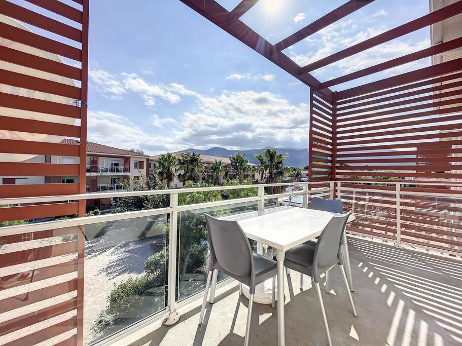 une table blanche et des chaises sur un balcon avec vue dans l'établissement 3279-T3 dans une résidence avec piscine, à Argelès-sur-Mer