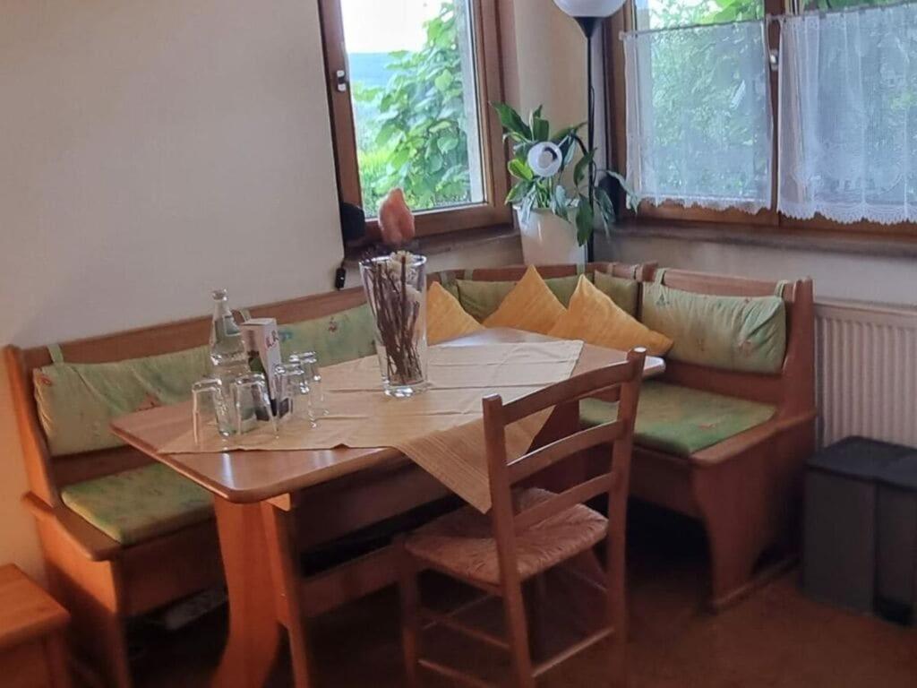 uma mesa de madeira com cadeiras, uma mesa e um sofá em House Schwarzwaldblick Ettenheim em Ettenheim