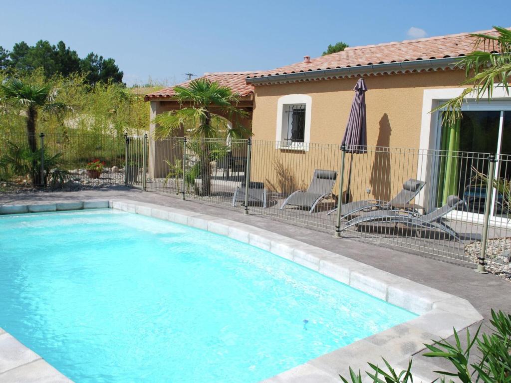 オリロルにあるCozy Villa in Sampzon with Swimming Poolの家の隣にスイミングプール(椅子、パラソル付)