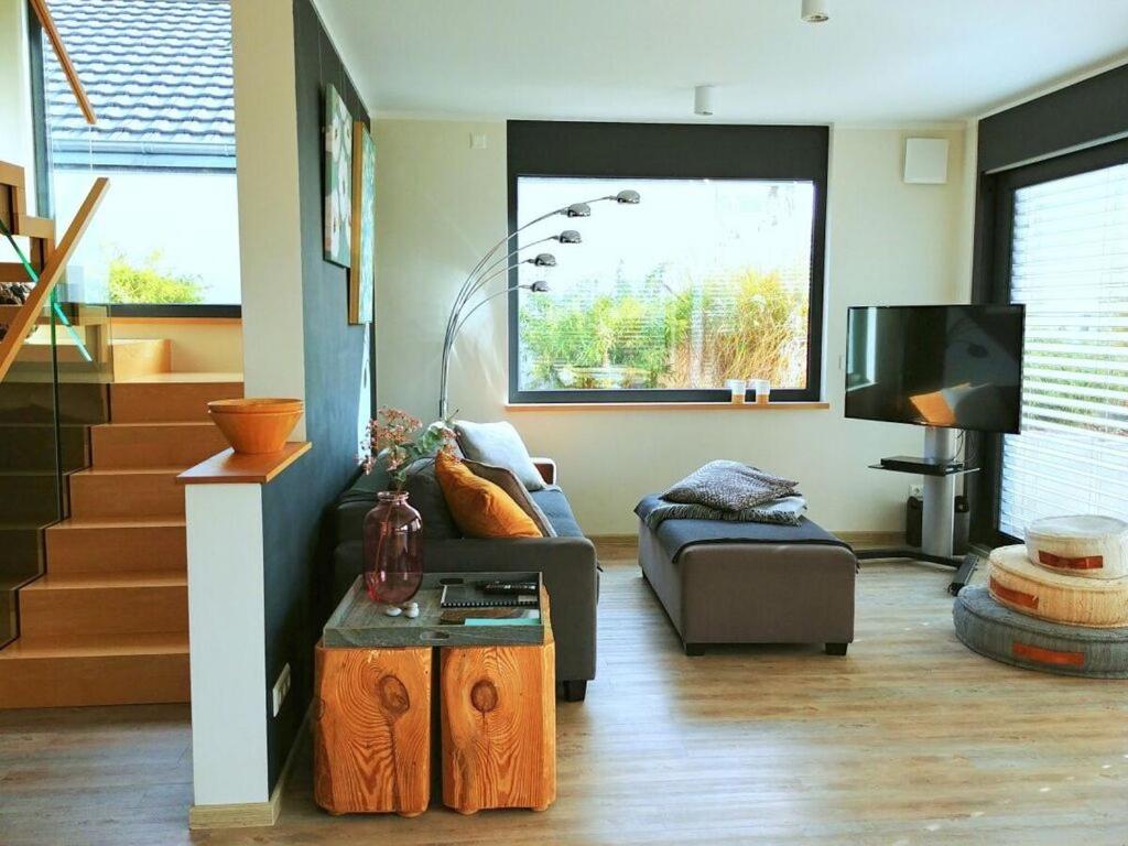 een woonkamer met een bank en een tv bij Holiday house house on Mühlfeldsee in Löbnitz