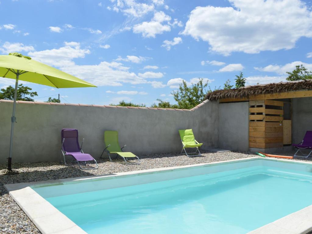 a swimming pool with chairs and an umbrella at Chic Holiday Home in Pradons with Swimming Pool in Pradons