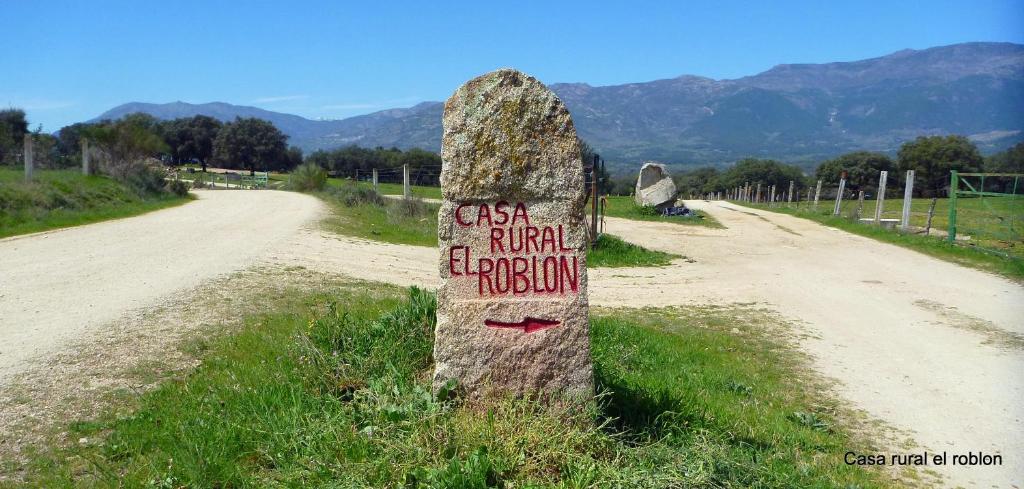 una señal de piedra en el costado de un camino de tierra en Casa Rural El Roblon, en Sartajada