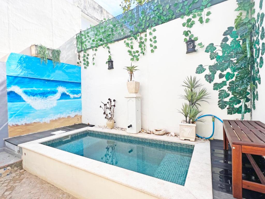 una piscina en una casa con una pintura en la pared en Casa Querida - Fuzeta, en Fuseta
