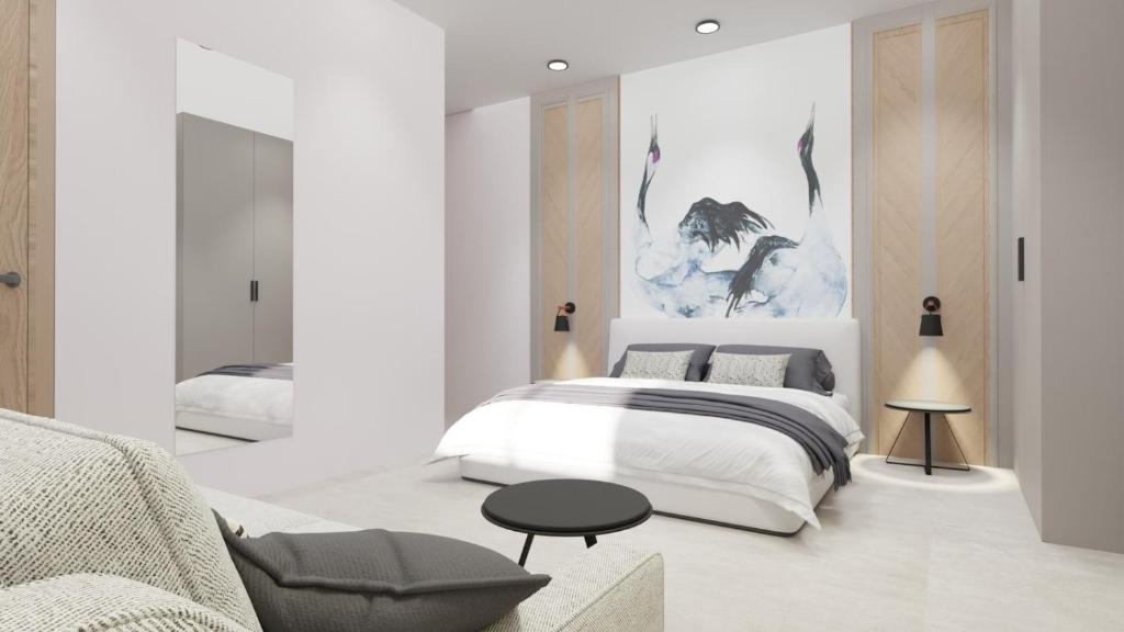 a white bedroom with a bed and a chair at SKIATHOS MODERNO in Skiathos