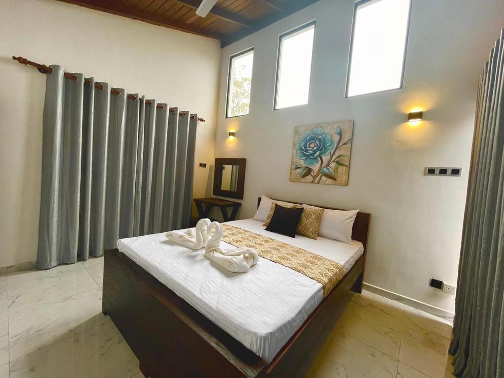 a bedroom with a large bed with two swans on it at Jumelle Residence in Horetuduwa