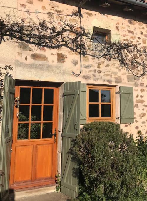 une maison avec une porte orange et une fenêtre dans l'établissement Le Petit Gîte de Milhac, à Milhac-de-Nontron