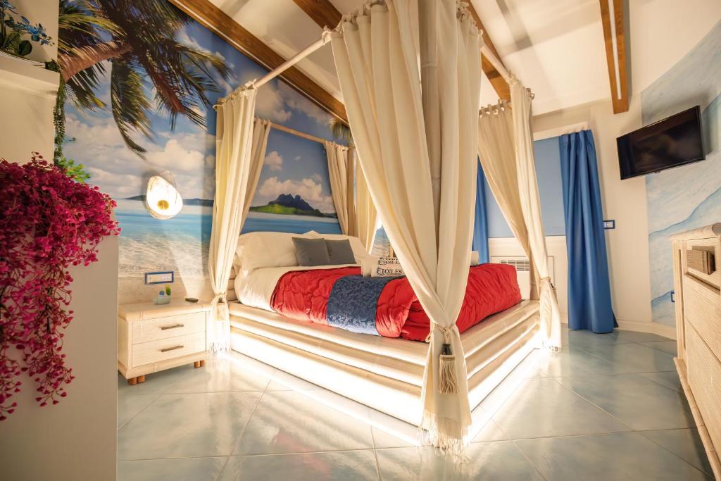 ein Schlafzimmer mit einem Himmelbett vor einem Fenster in der Unterkunft Étoiles Luxury guest house Resort in Palmi