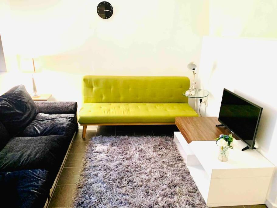 un soggiorno con divano verde e tavolo di HEART of Birmingham-City Centre a Birmingham