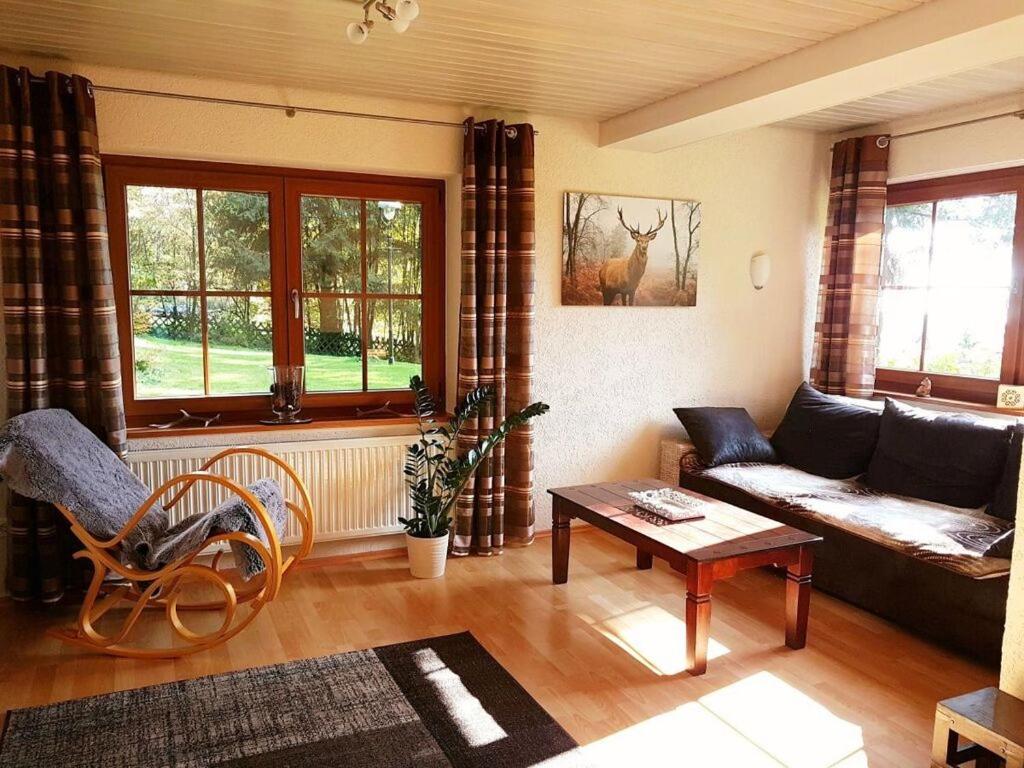 uma sala de estar com um sofá e uma mesa em Crystal holiday home em Sankt Englmar