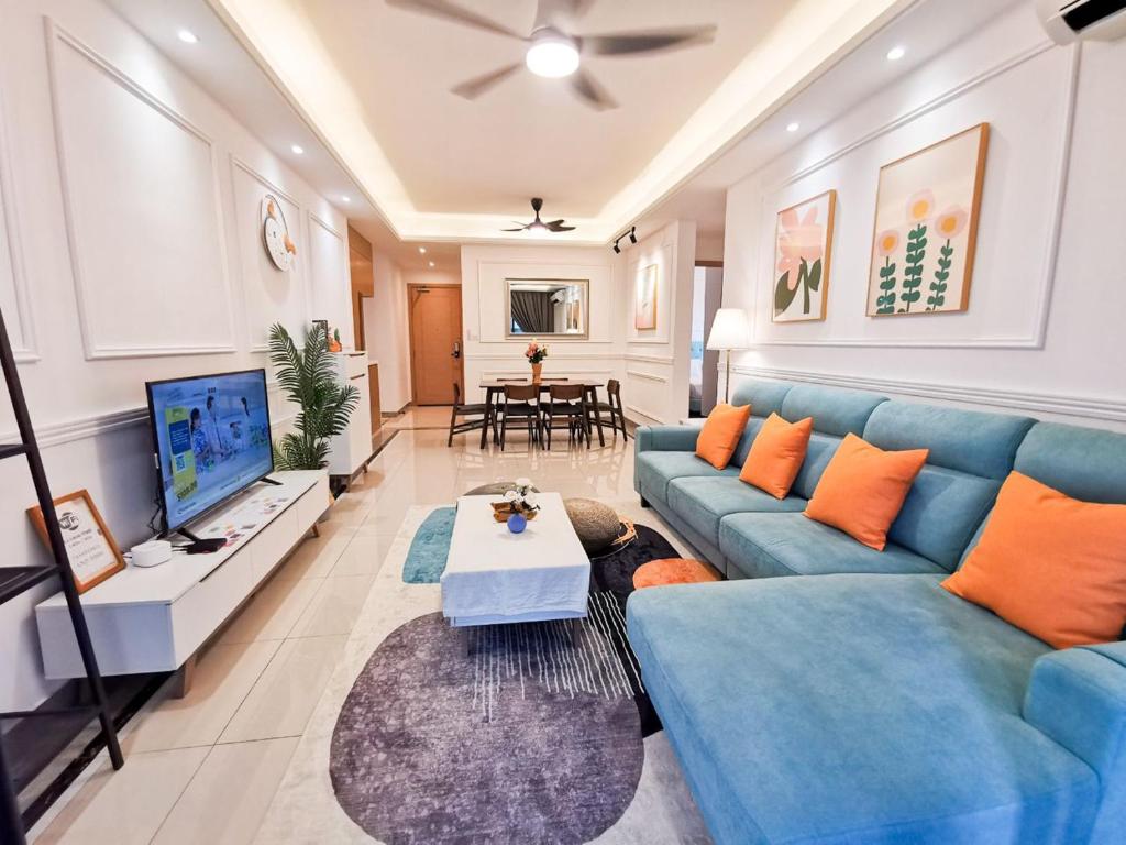 a living room with a blue couch and a tv at R&F PRINCESS COVE at ANJU in Johor Bahru