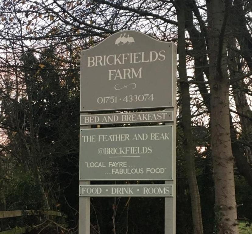 znak dla ceglanych gospodarstw rolnych z drzewami w obiekcie Brickfields Farm w mieście Kirkbymoorside