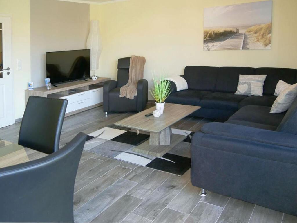 sala de estar con sofá azul y TV en Holiday home Klinger, en Todendorf auf Fehmarn