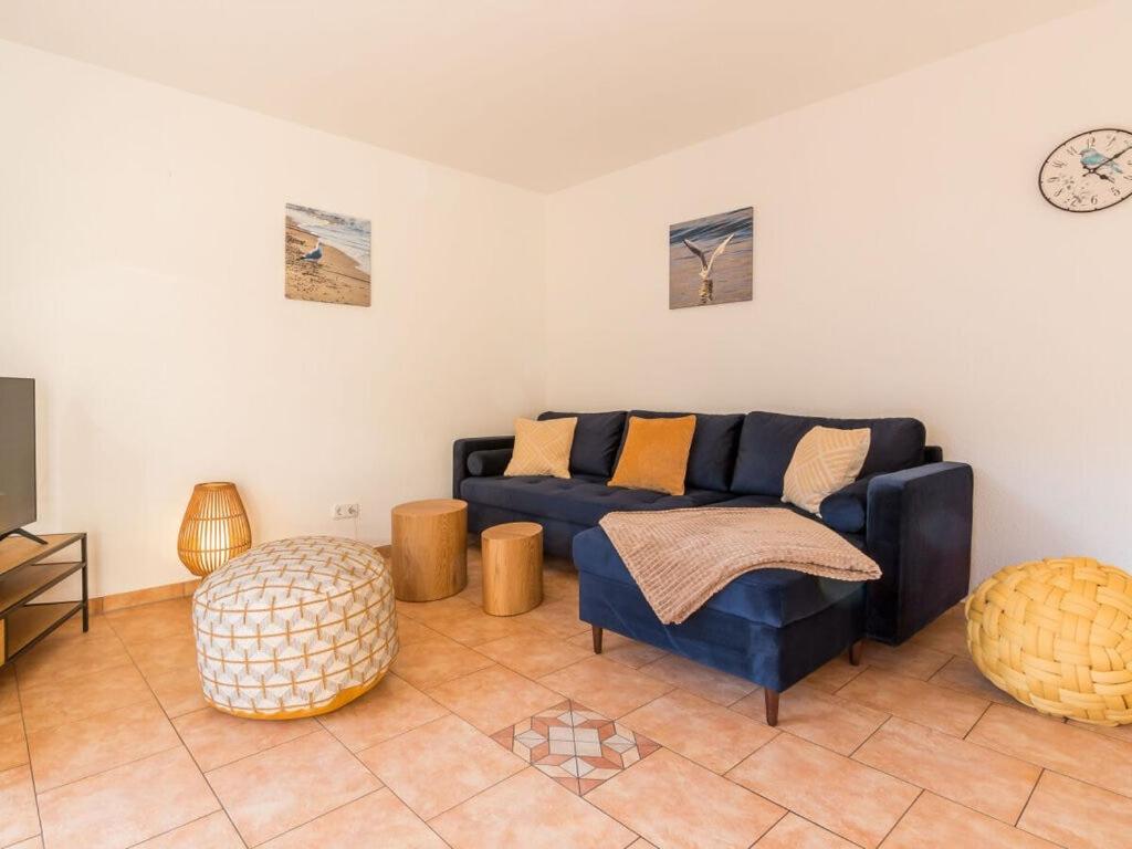 ein Wohnzimmer mit einem blauen Sofa und einem Tisch in der Unterkunft Holiday apartment coastal love in Wustrow