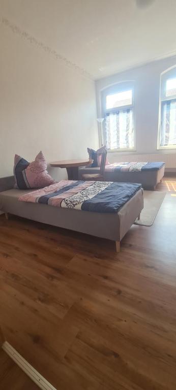 two beds in a room with wooden floors at Monteurwohnungen in Aschersleben