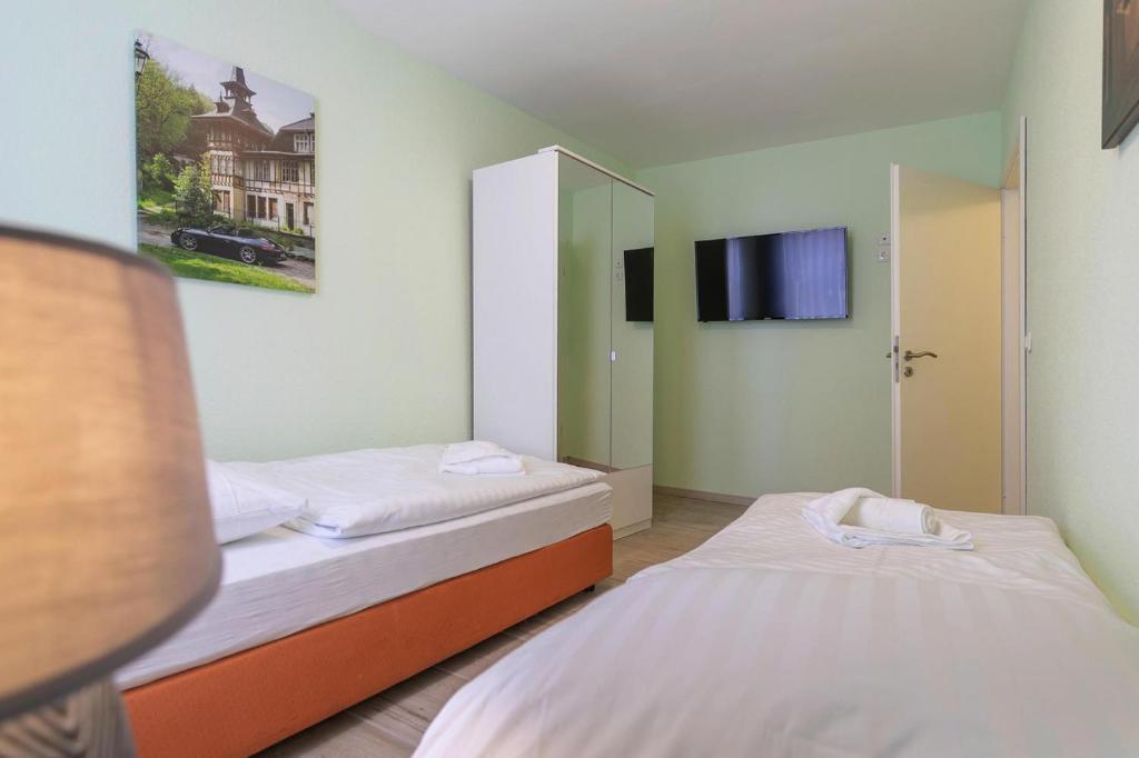 2 Betten in einem Zimmer mit einem TV in der Unterkunft Apartment Schlossblick Wernigerode in Wernigerode