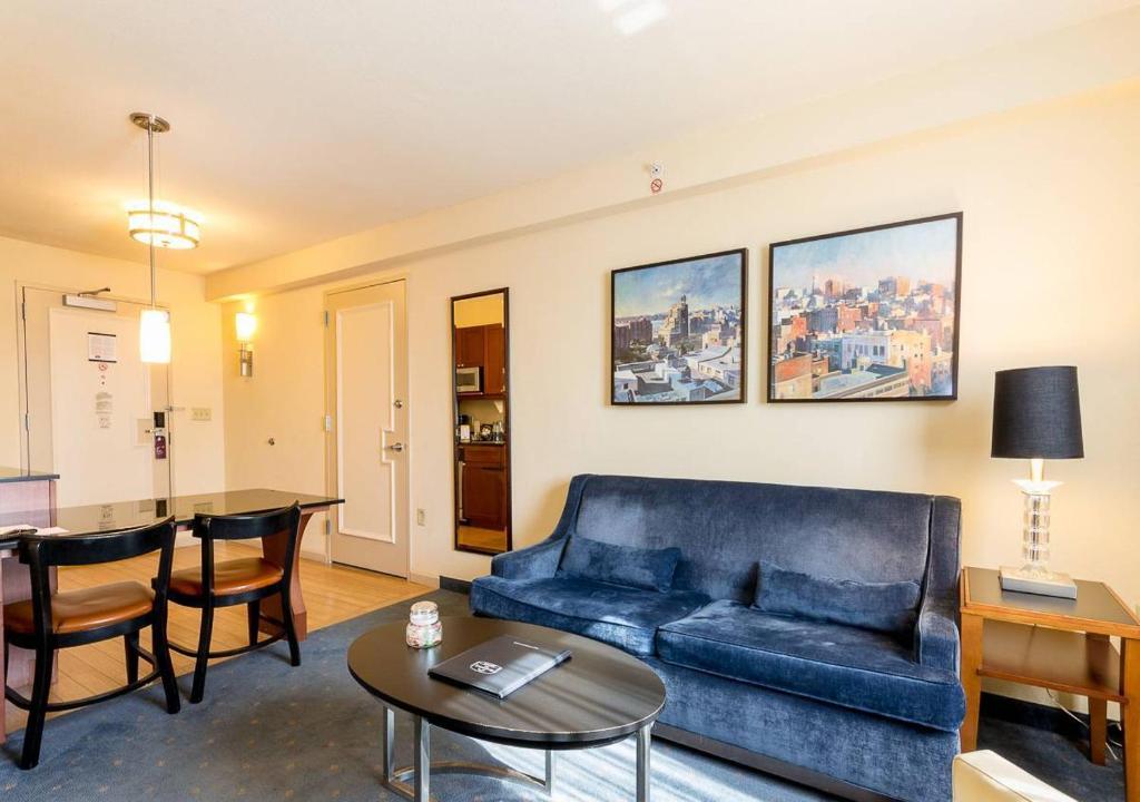 a living room with a blue couch and a table at Beautiful & Cozy 1BR in NYC! in New York