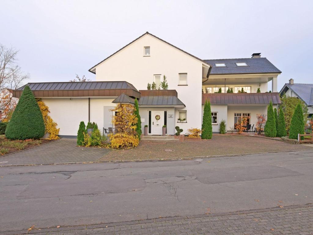 a large white house with a driveway at Spacious Apartment in Madfeld with Private Terrace in Madfeld