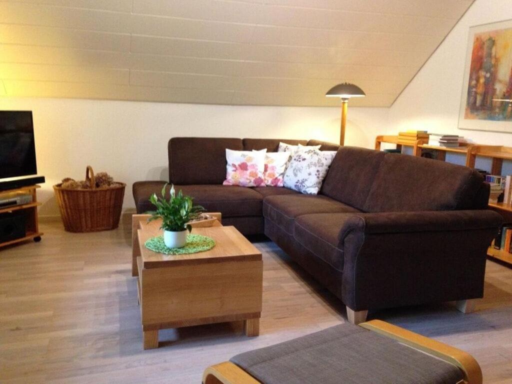 een woonkamer met een bruine bank en een salontafel bij Holiday apartment Xantener Aue in Xanten