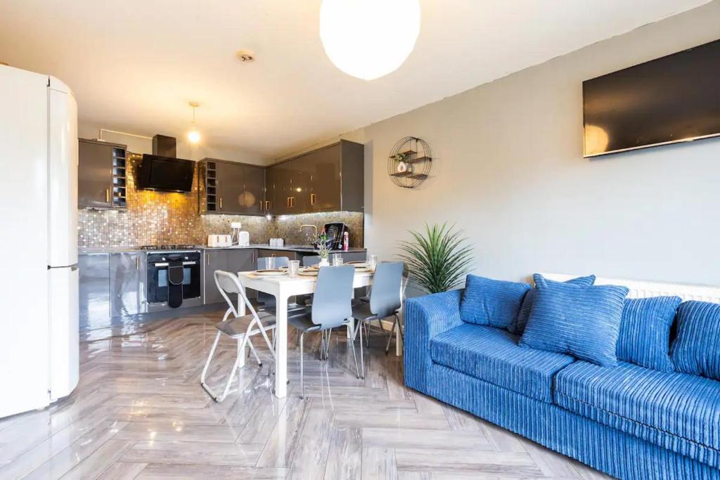 un soggiorno con divano blu e tavolo di Large 5-Bed House in Leeds Fits 10 Free Parking a Leeds
