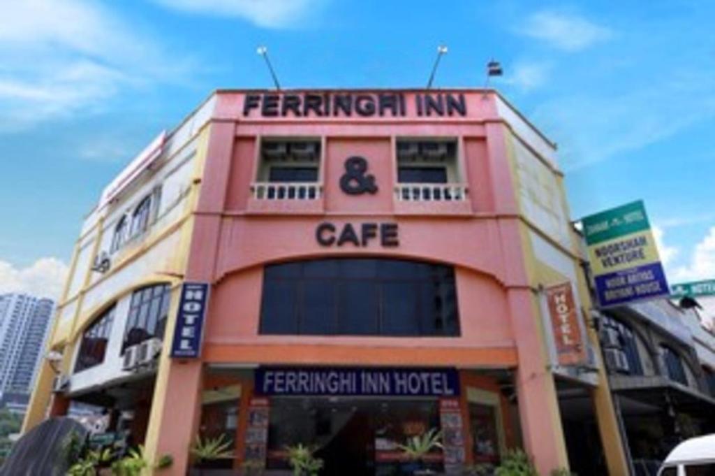 a pink building with a cafe on top of it at Ferringhi Inn Hotel in Batu Ferringhi