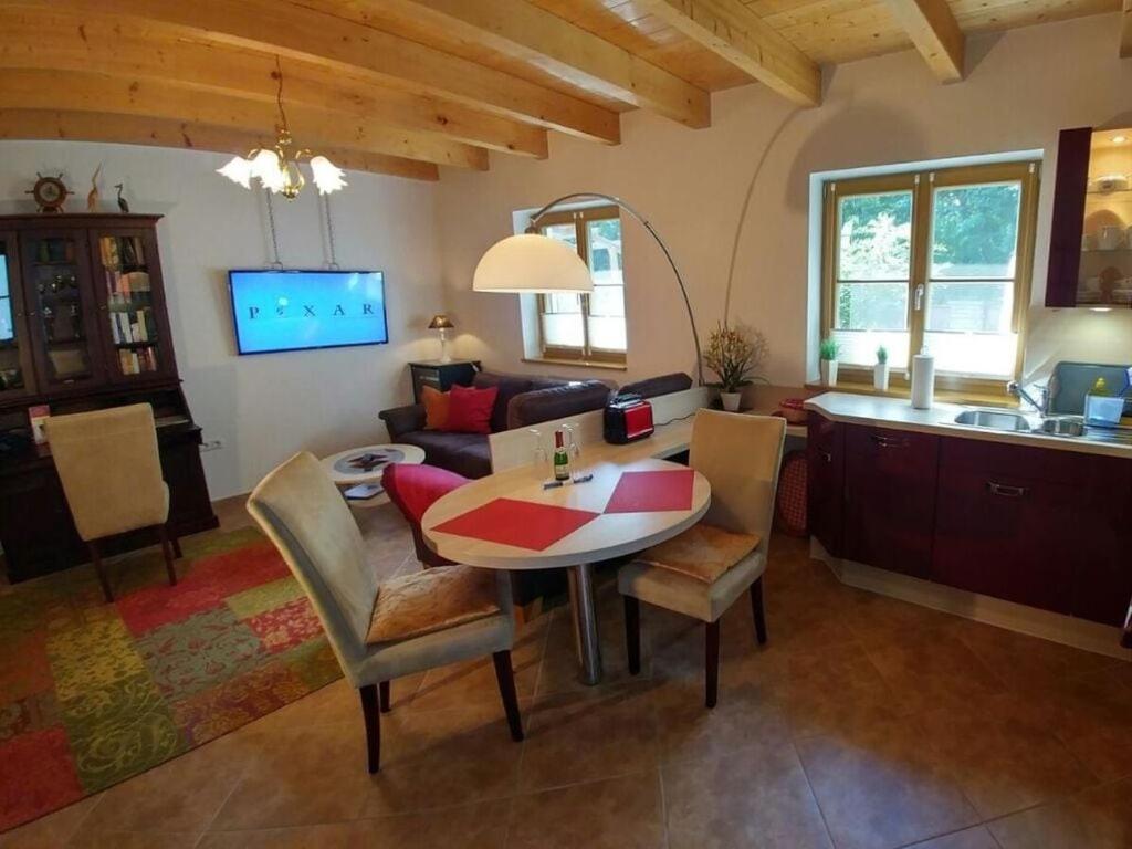 Pleasant apartment in Schwielowsee في شيلووسي: مطبخ وغرفة معيشة مع طاولة وكراسي