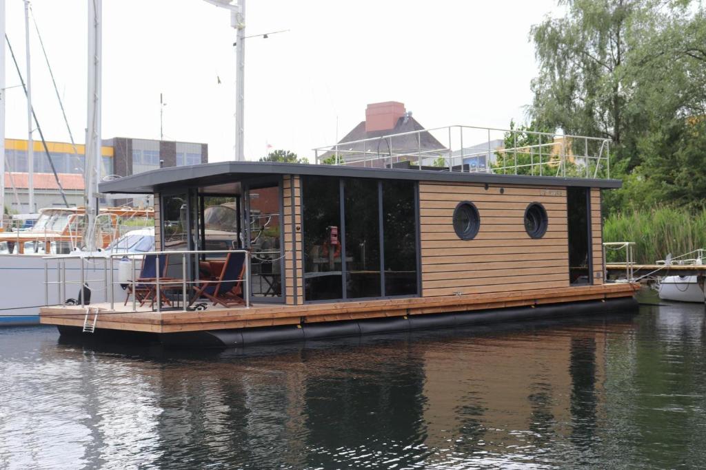 Houseboat Leni Flensburg في فلنسبورغ: منزل صغير على قارب في الماء