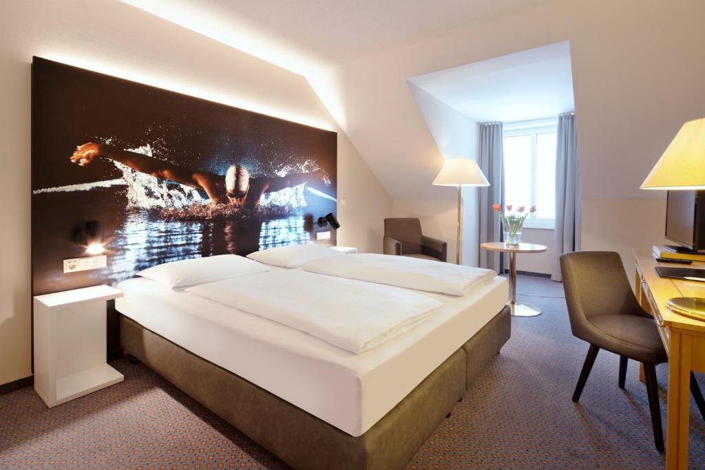 ein Schlafzimmer mit einem großen weißen Bett in einem Zimmer in der Unterkunft Erikson Hotel in Sindelfingen