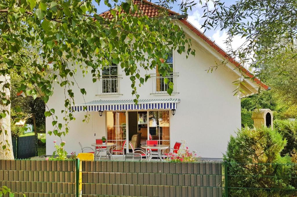 a white house with a table and chairs at Cottages at the Kummerower See Verchen in Verchen