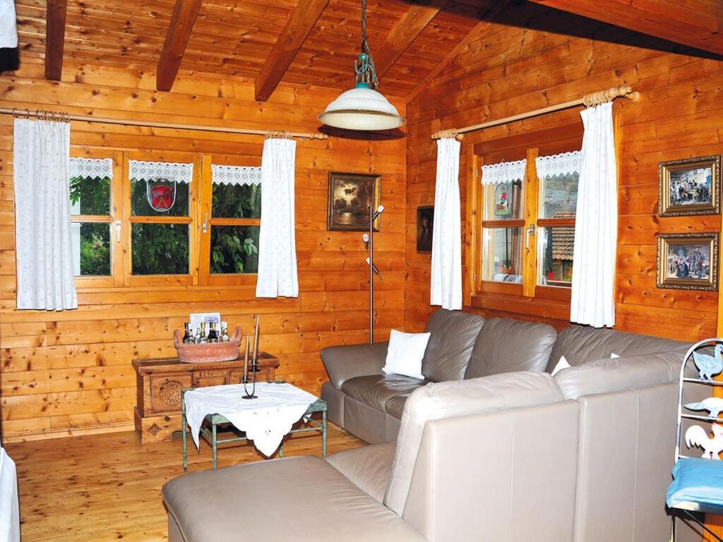 uma sala de estar com um sofá numa cabana de madeira em Apartment near West Hamburg em Neubeuern