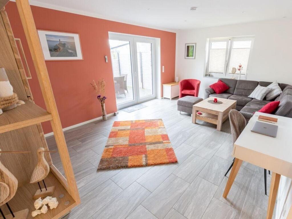 a living room with a couch and a table at North Sea holiday home Zinnäcker in Almdorf
