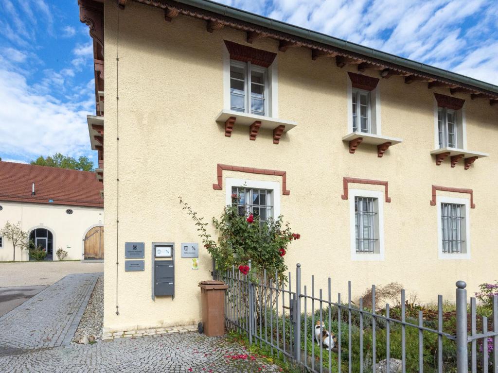 una casa amarilla con una valla delante de ella en Lovely Holiday Home in Haunsheim, en Haunsheim