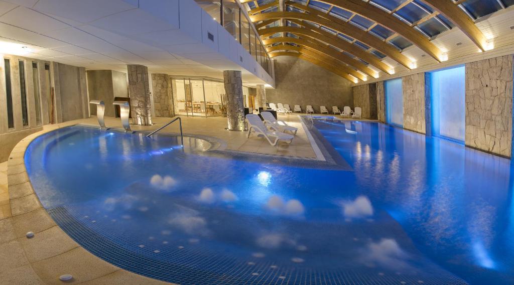 a large swimming pool in a hotel with blue water at Hotel Cristal in San Carlos de Bariloche