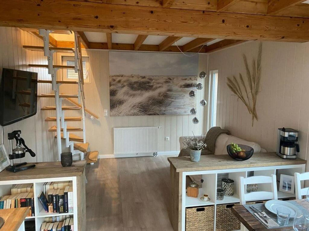 a living room with a staircase and a room with bookshelves at Holiday home The Beach Hut in Schönhagen