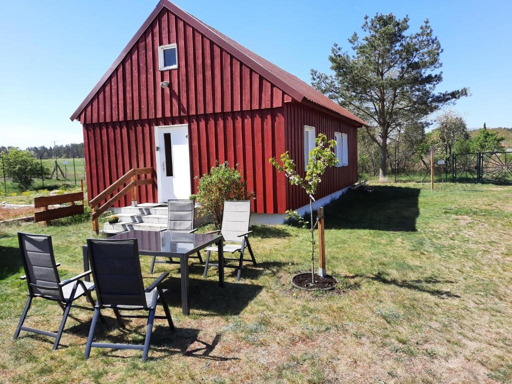 a table and chairs in front of a red barn at Holiday house at the Vilzsee Mirow in Diemitz