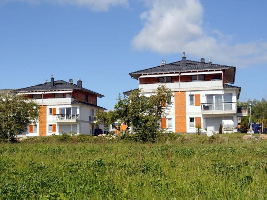 twee gebouwen op een heuvel met een grasveld bij Holiday apartment "Sun Catcher" in Dierhagen